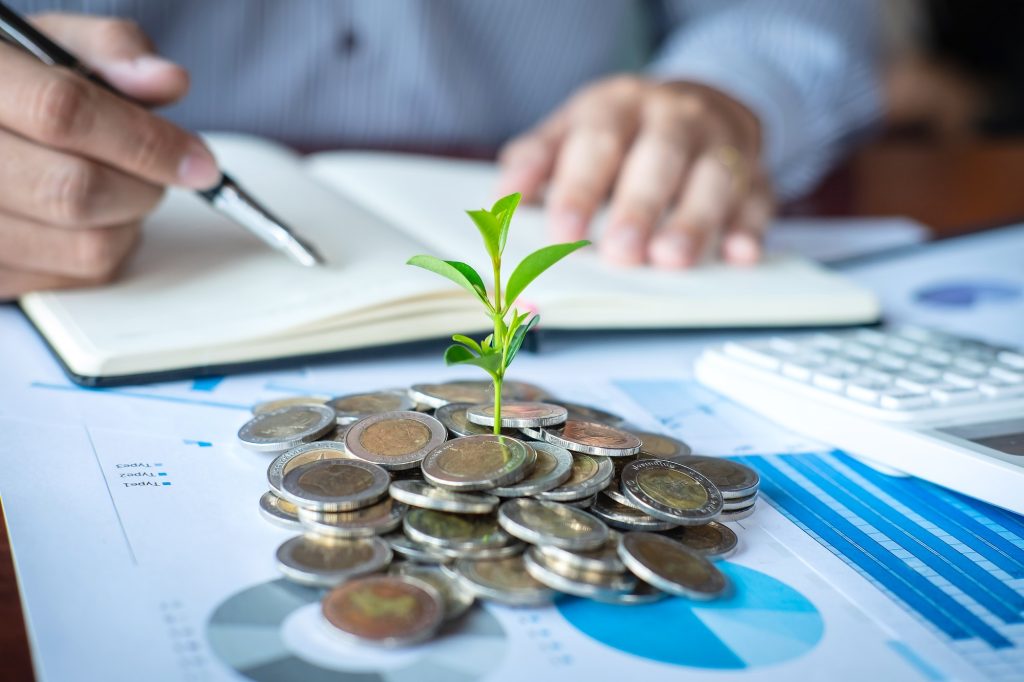 Businessman accountant making notes at report doing finances and calculate about cost of investment