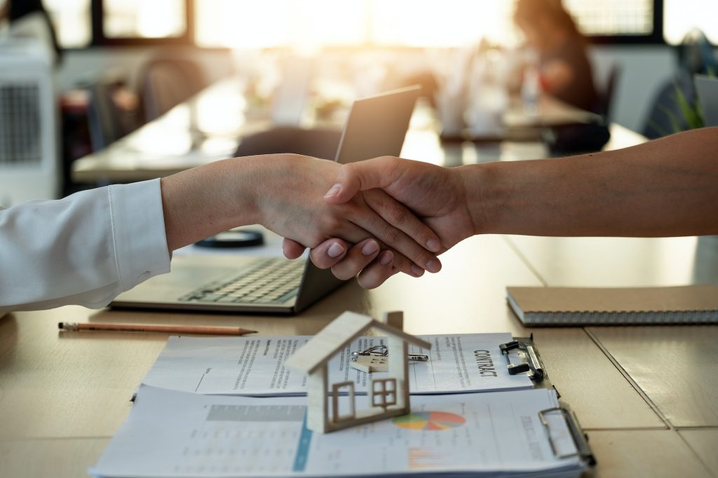 Handshake a successful real estate transaction in an office. Business people shake hands after